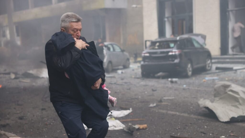 Man walking through smoke after Russian drone strike in Kharkiv
